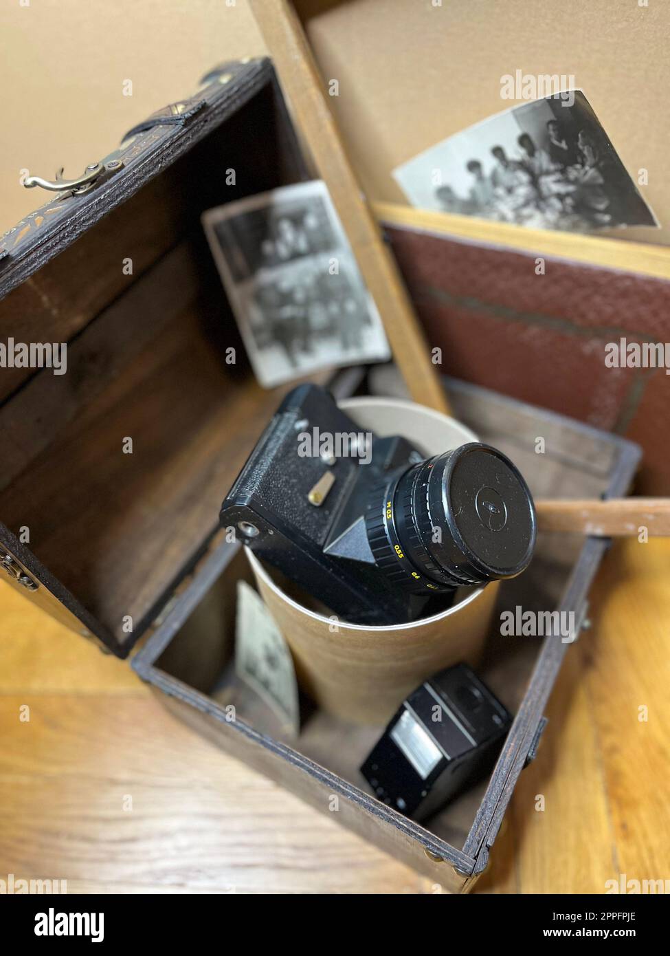 Un vieil appareil photo reflex dans un cadre et dans une poitrine Banque D'Images