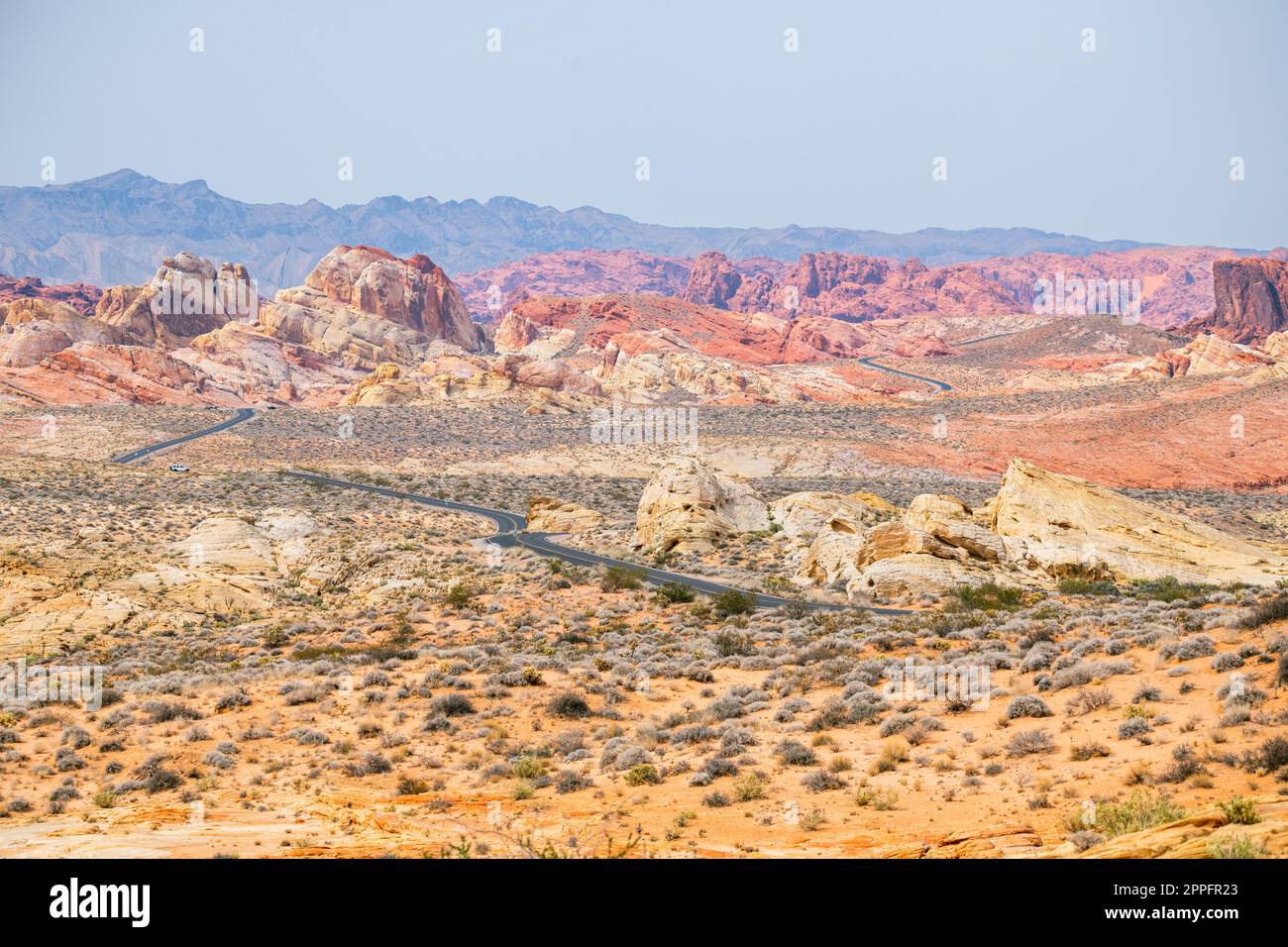 Route sinueuse dans le désert avec des montagnes rougeâtres dans le bkgrnd Banque D'Images