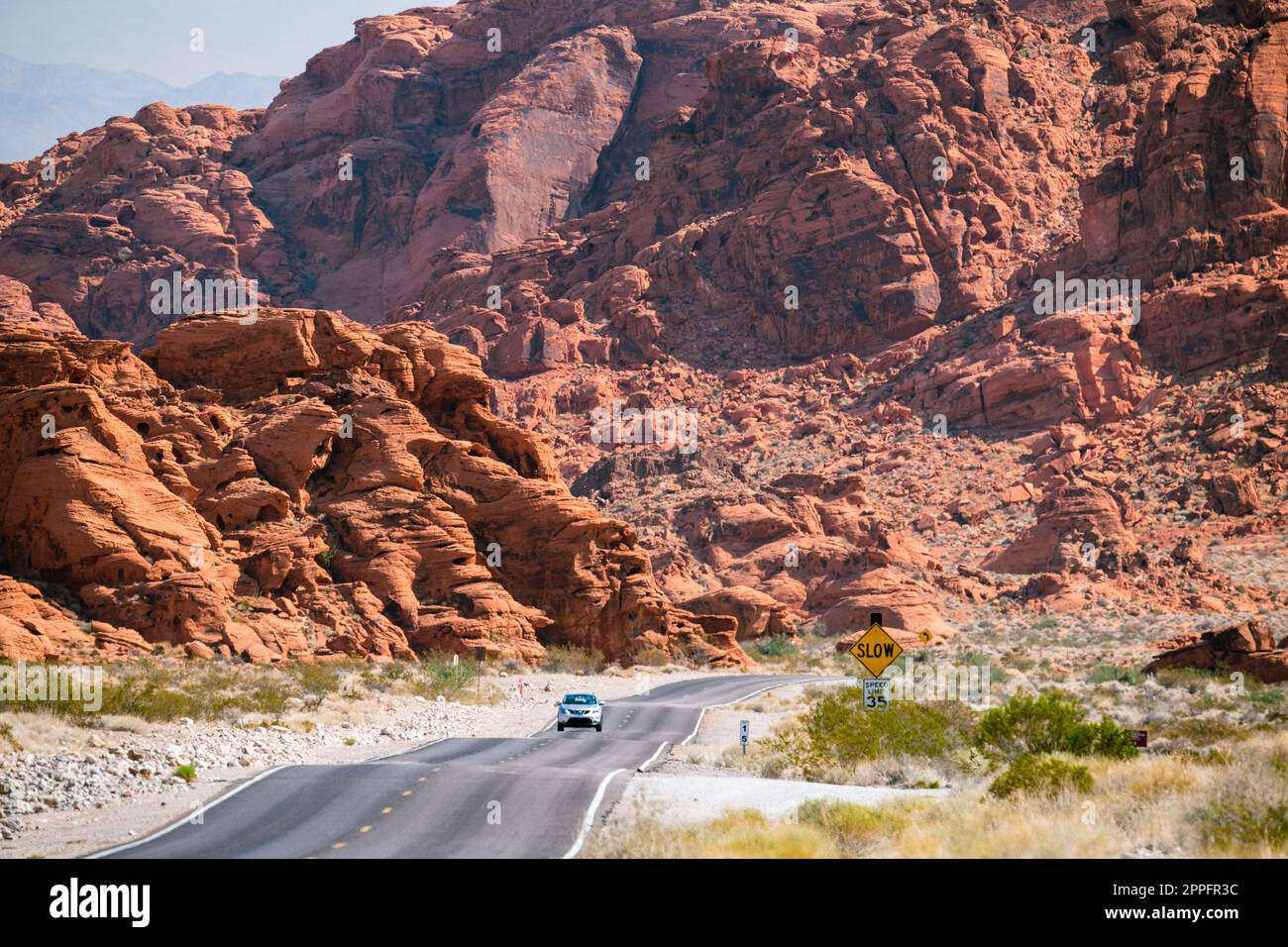 Route sinueuse dans le désert avec des montagnes rougeâtres dans le bkgrnd Banque D'Images