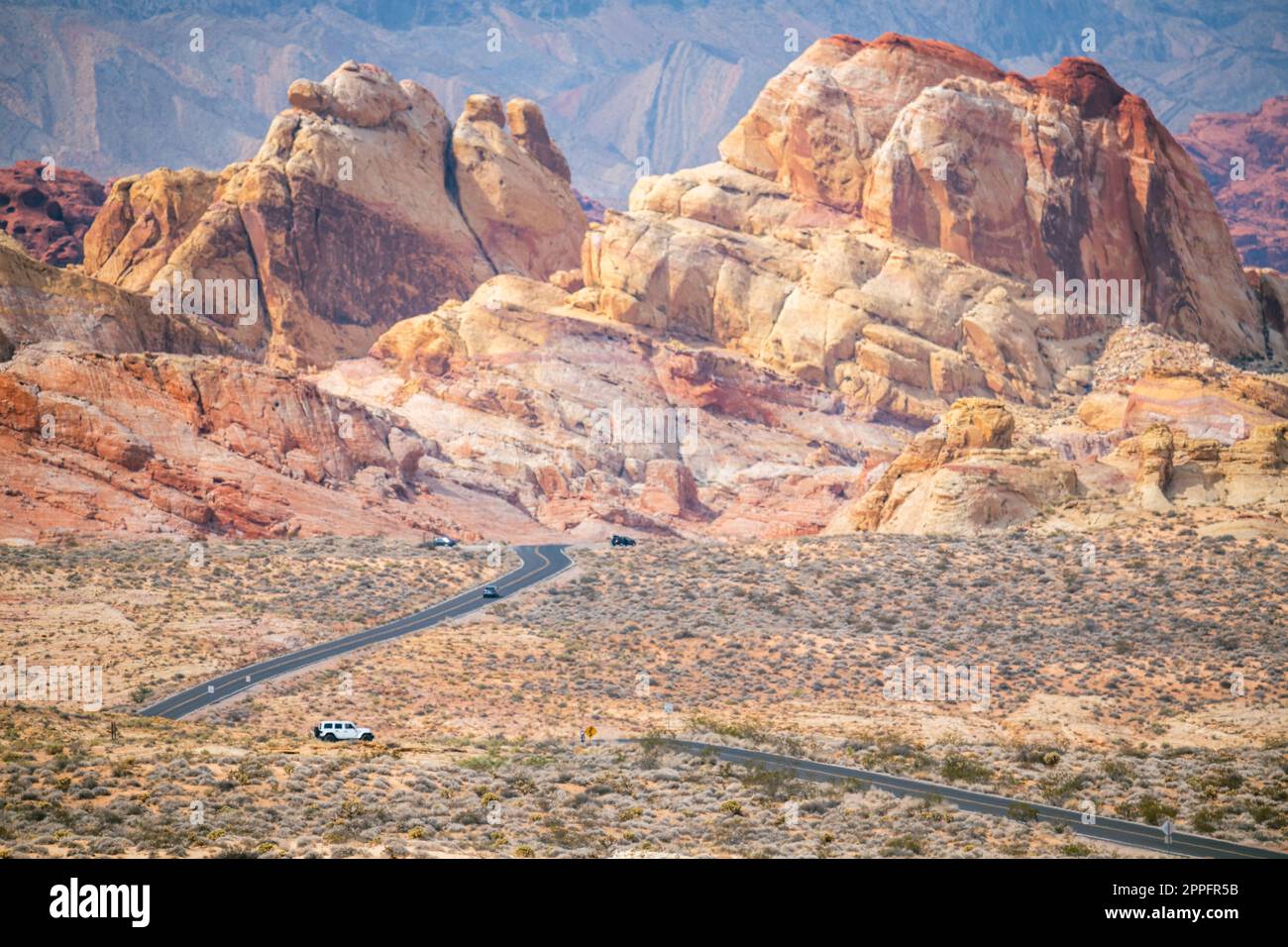 Route de gauche à droite dans le désert avec des montagnes rouges dans le bkgrnd Banque D'Images