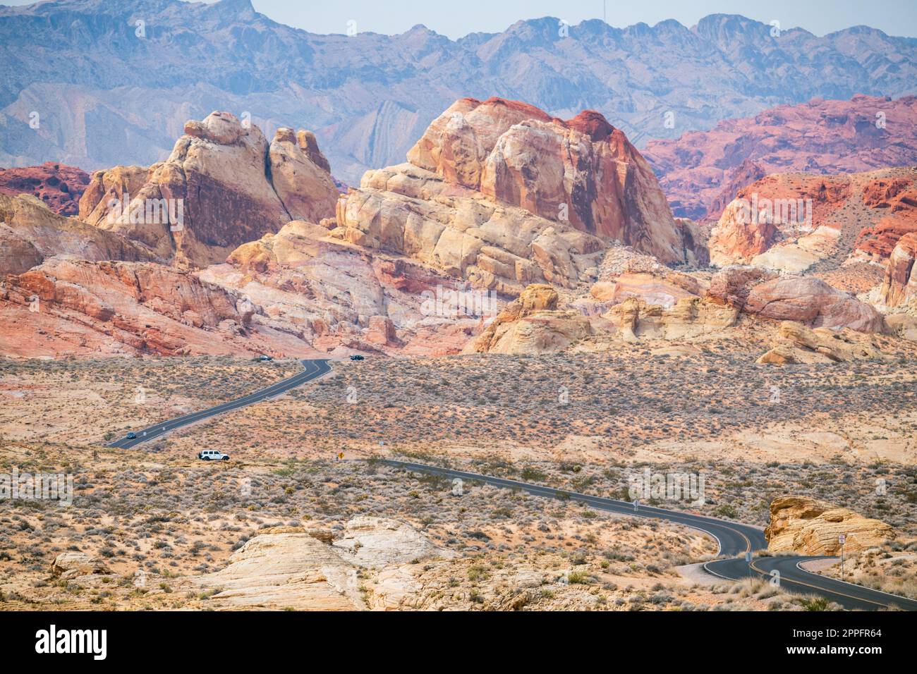 Route de gauche à droite dans le désert avec des montagnes rouges dans le bkgrnd Banque D'Images
