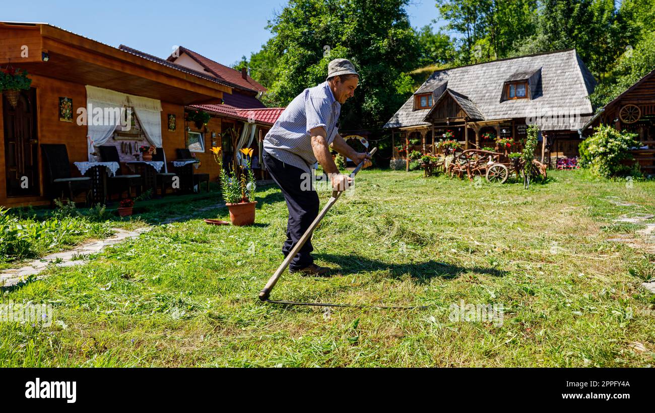 Un fermier coupe du gras avec un sens en Roumanie Banque D'Images