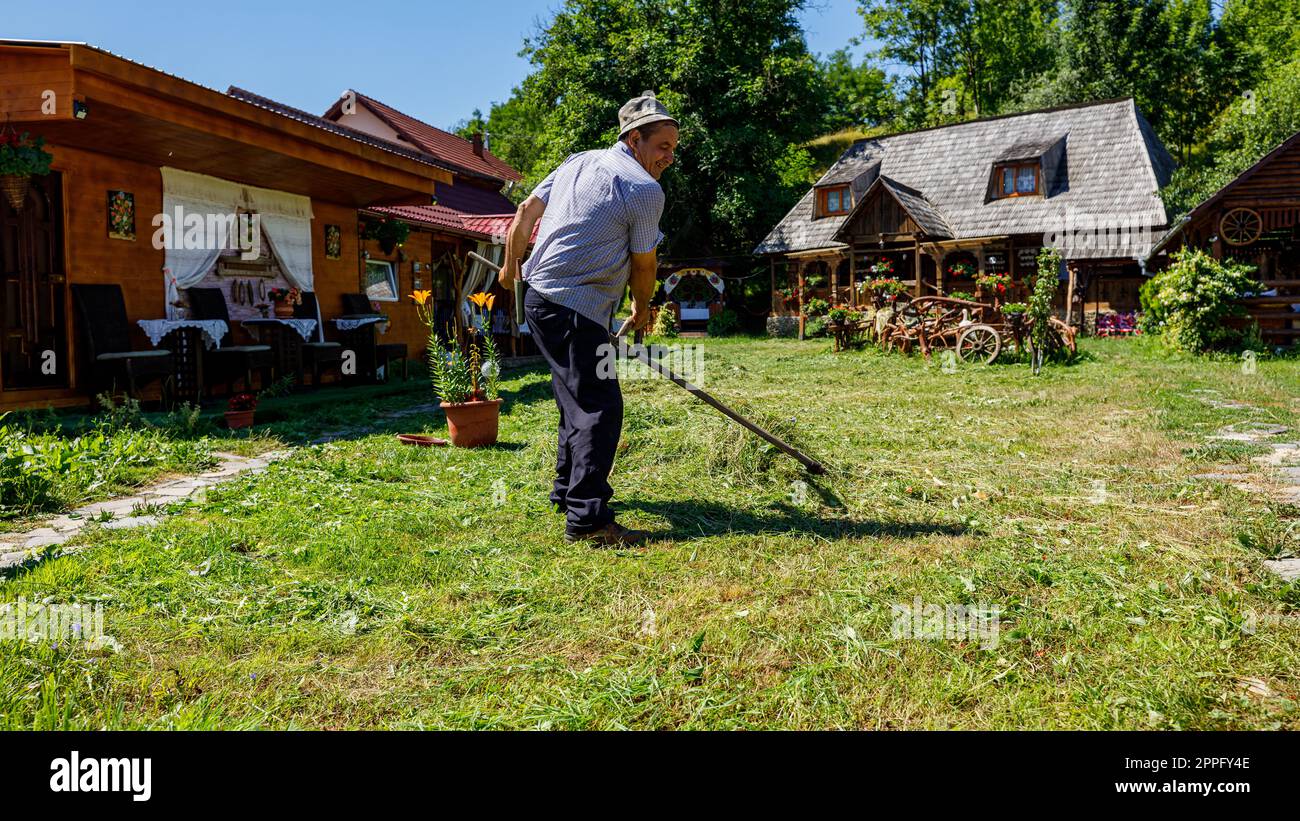 Un fermier coupe du gras avec un sens en Roumanie Banque D'Images