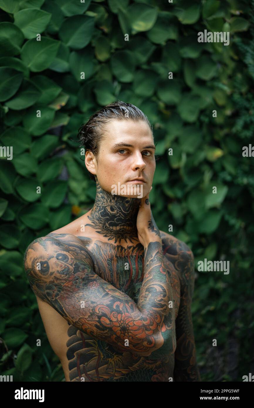 Jeune homme beau avec tatouages de style japonais. Banque D'Images