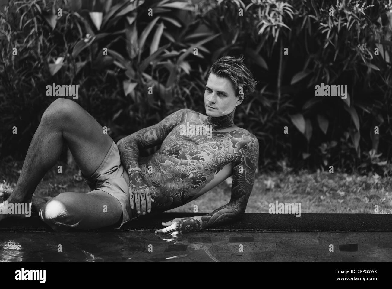 Jeune homme beau avec tatouages de style japonais. Banque D'Images