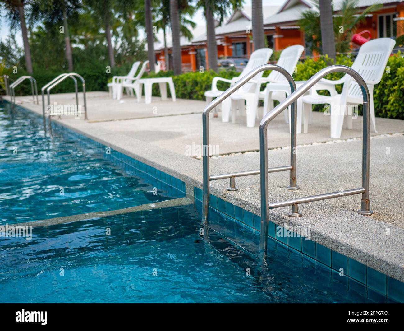 .Escalier en acier inoxydable vers la piscine. mains courantes de haut en bas de la piscine. Banque D'Images