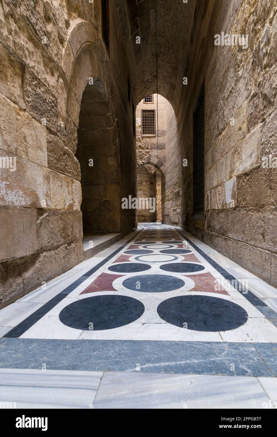 Passage voûté menant à la cour de la mosquée Sultan Qalawun avec sol en marbre coloré, le Caire Banque D'Images