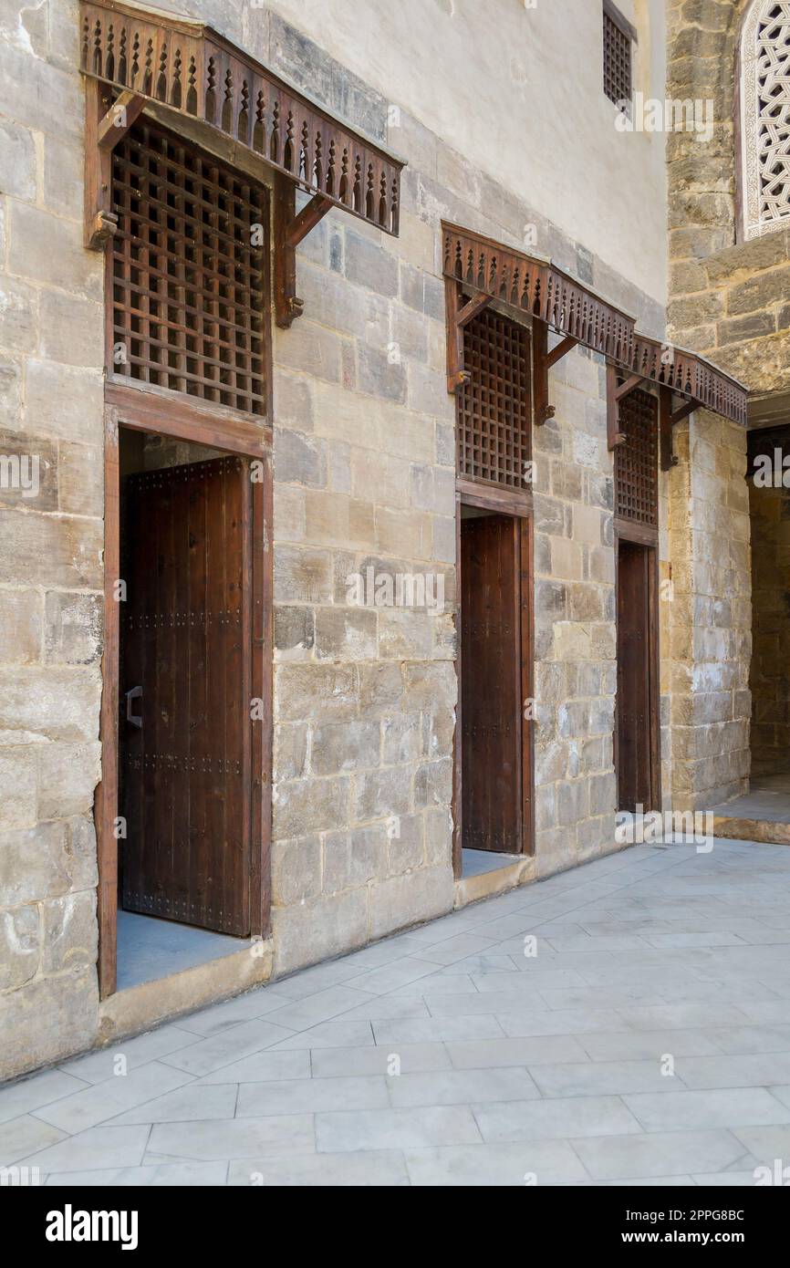 Façade de vieux mur de briques de pierre abandonné avec trois portes ouvertes en bois patiné Banque D'Images