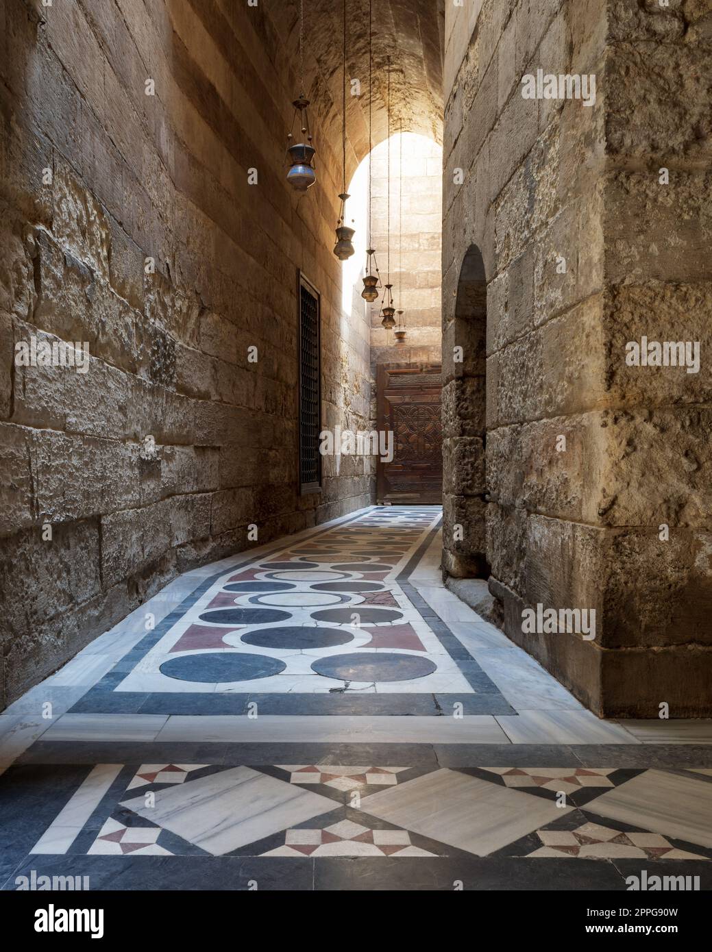 Passage voûté menant à la cour de la mosquée Sultan Qalawun avec sol en marbre coloré, le Caire Banque D'Images