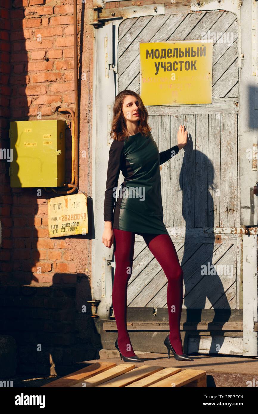 Mannequin posant près de la porte de l'usine avec plaque d'avertissement. Banque D'Images