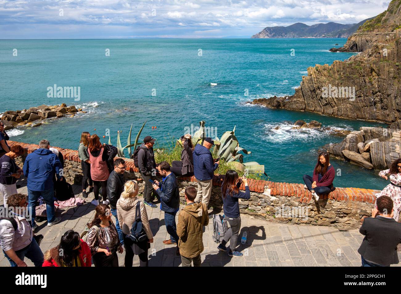 Un groupe de touristes sur la terrasse dans un petit village au bord de la mer Ligurienne, Riomaggiore, Cinque Terre, Italie Banque D'Images