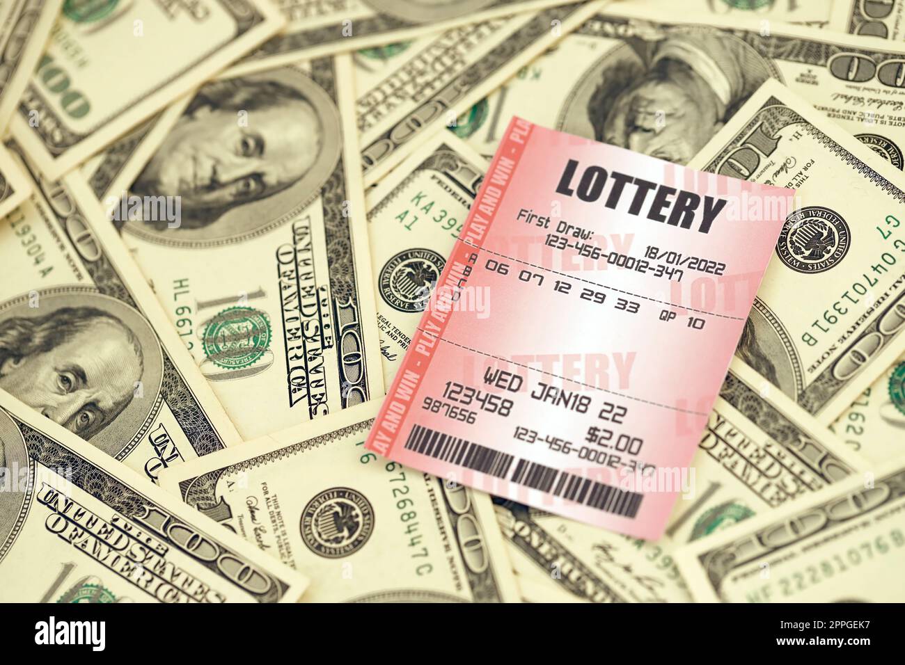 Billet de loterie rouge se trouve sur une grande quantité de billets de cent dollars. Concept de jeu de loterie ou dépendance au jeu. Gros plan Banque D'Images