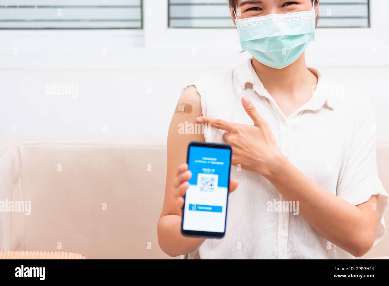 femme montrant du plâtre adhésif sur le bras elle a vacciné et montrant l'application smartphone écran numérique mobile vacciné Banque D'Images