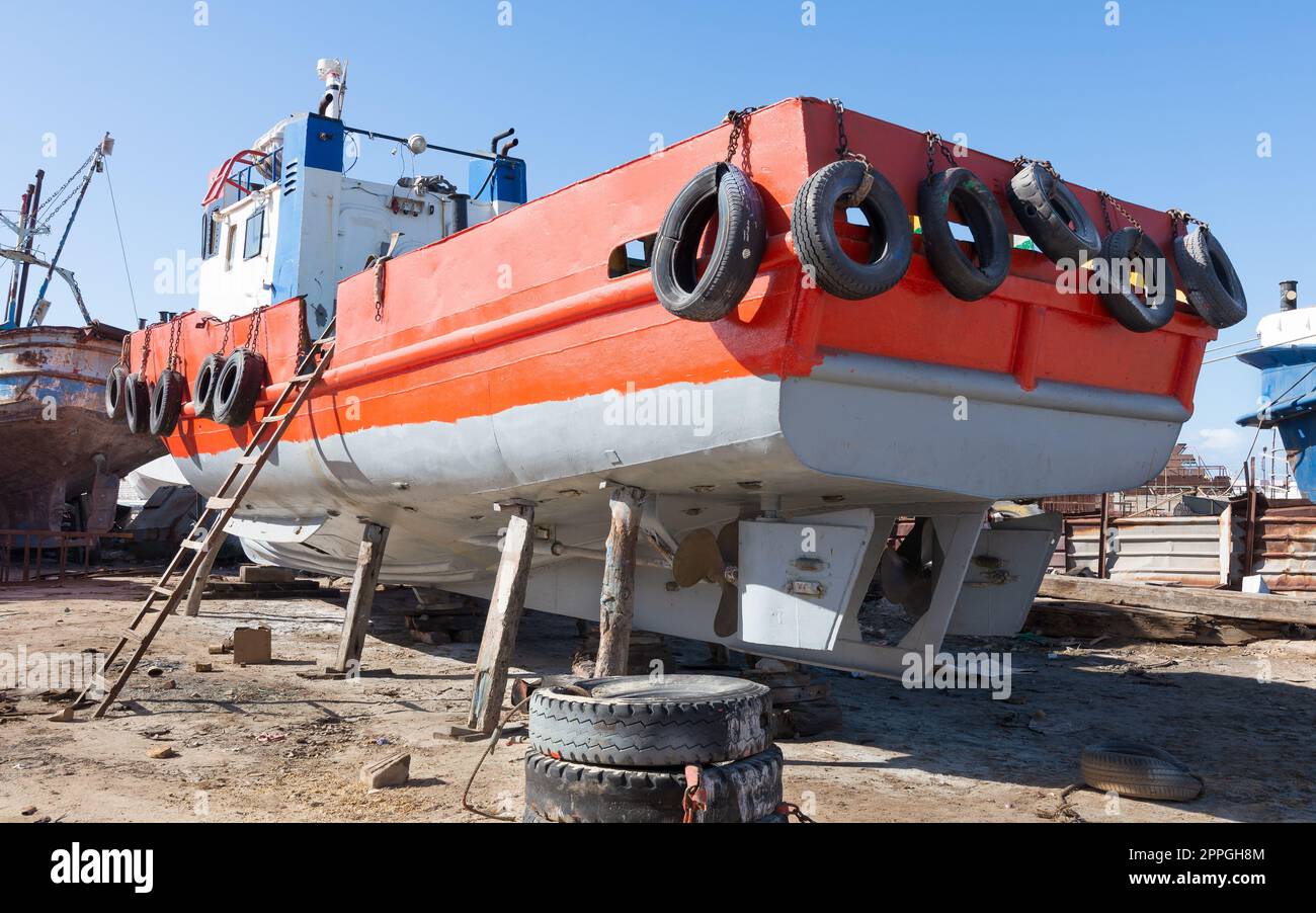 Vieux navire rouillé orange en réparation sur cale sèche grungy dans le chantier naval dans la vieille usine de construction navale Banque D'Images