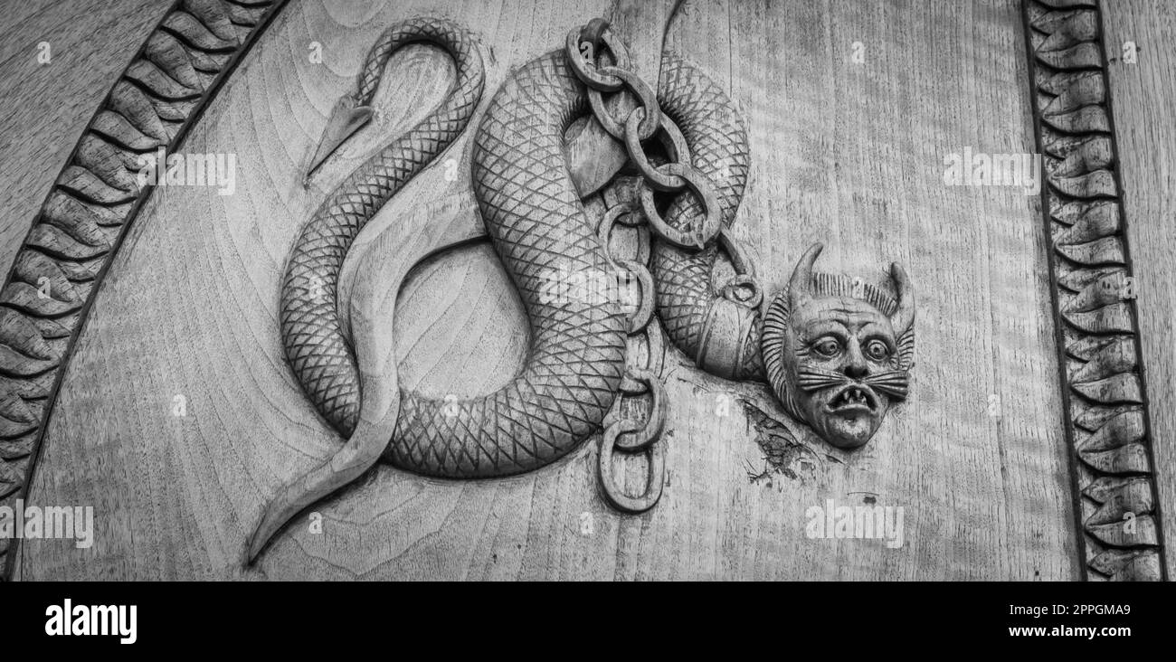 Symbole serpent de diable. Créature magique fantaisie sur une vieille porte, abbaye du 12th siècle en Italie. Banque D'Images