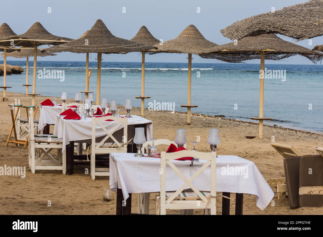 festivaly tables posées entre les parasols près de la mer Banque D'Images