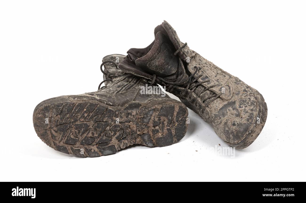 Chaussures noires, recouvertes de boue, isolées sur blanc Banque D'Images