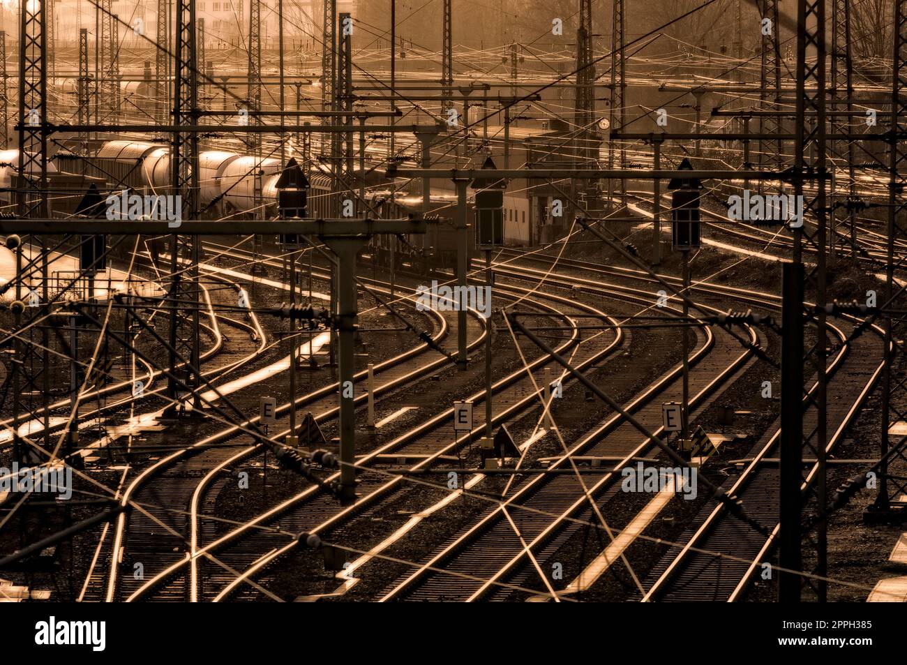 La cour de marshalling avec des pistes et des trains de marchandises garées dans un téléobjectif rétroéclairé par le soleil Banque D'Images