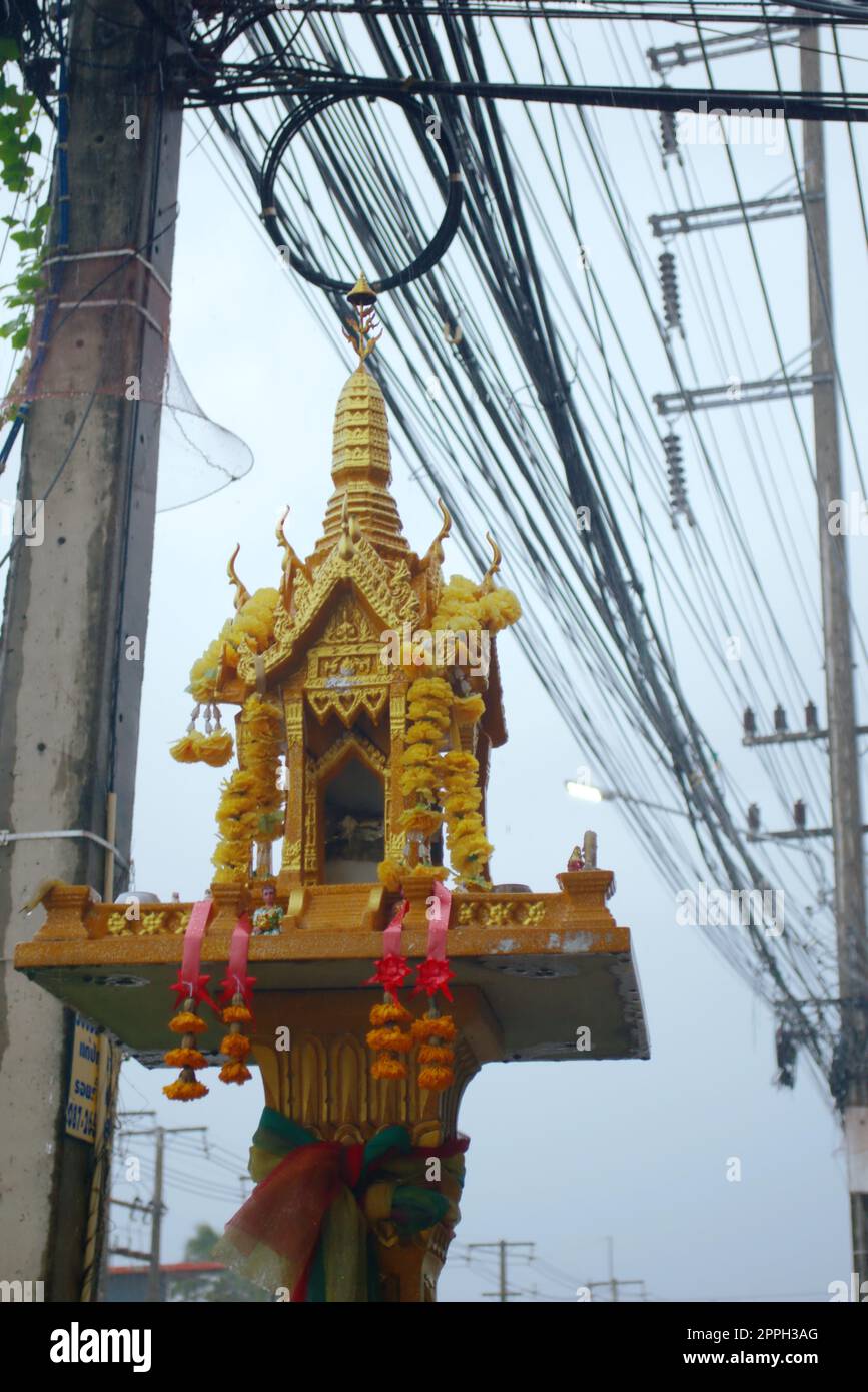 Petite golden temple bouddhiste dans la rue à Phuket, Thaïlande, un jour de pluie. Banque D'Images