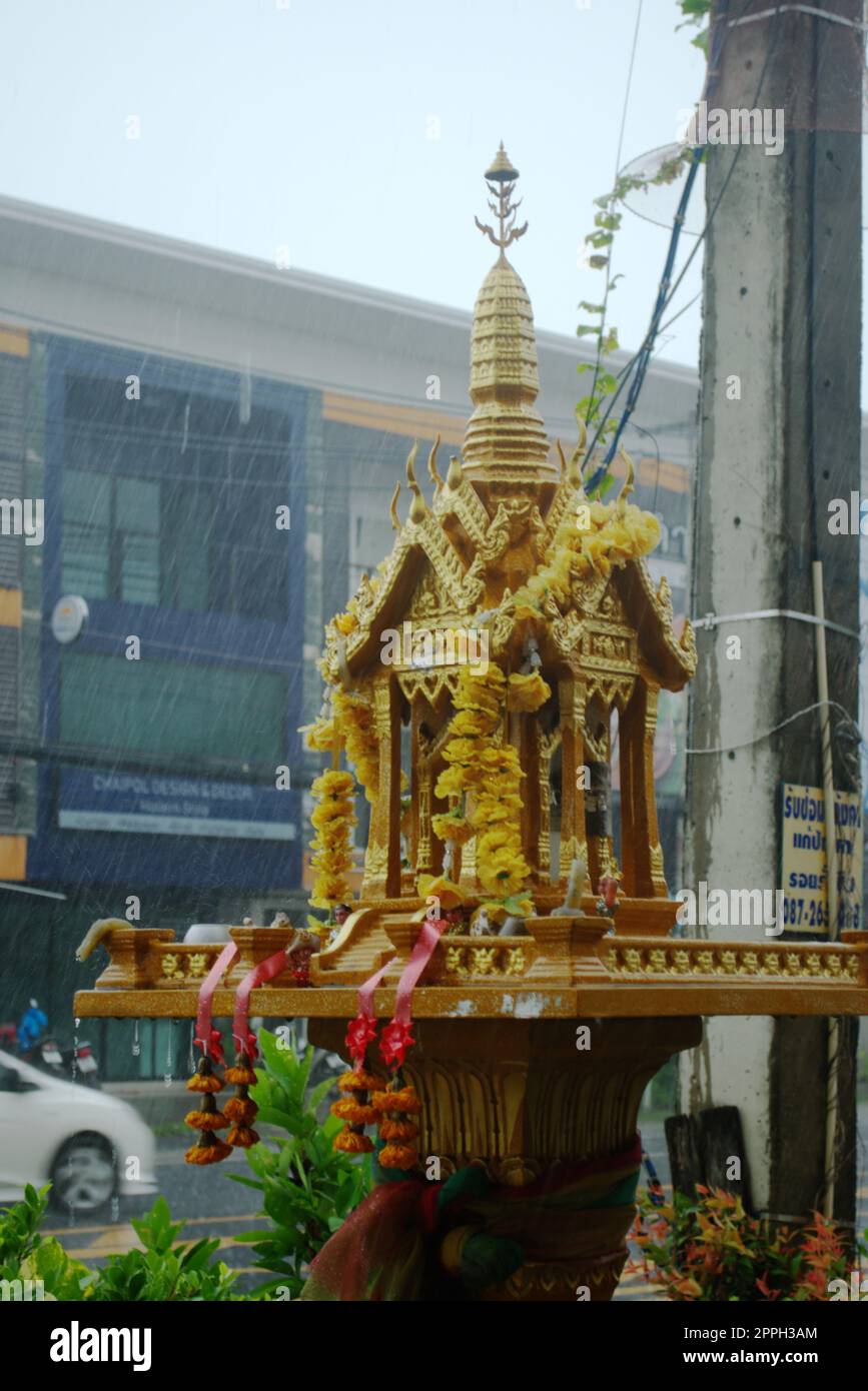 Petite golden temple bouddhiste dans la rue à Phuket, Thaïlande, un jour de pluie. Banque D'Images