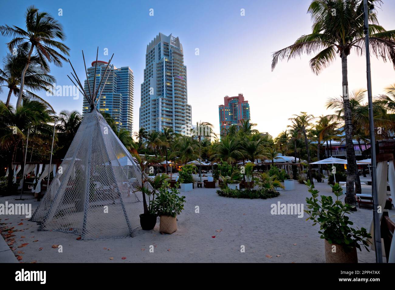 Vue sur le parc de palmiers et les gratte-ciel de Miami Beach au crépuscule Banque D'Images Vue sur le parc de palmiers et les gratte-ciel de Miami Beach au crépuscule Banque D'Images