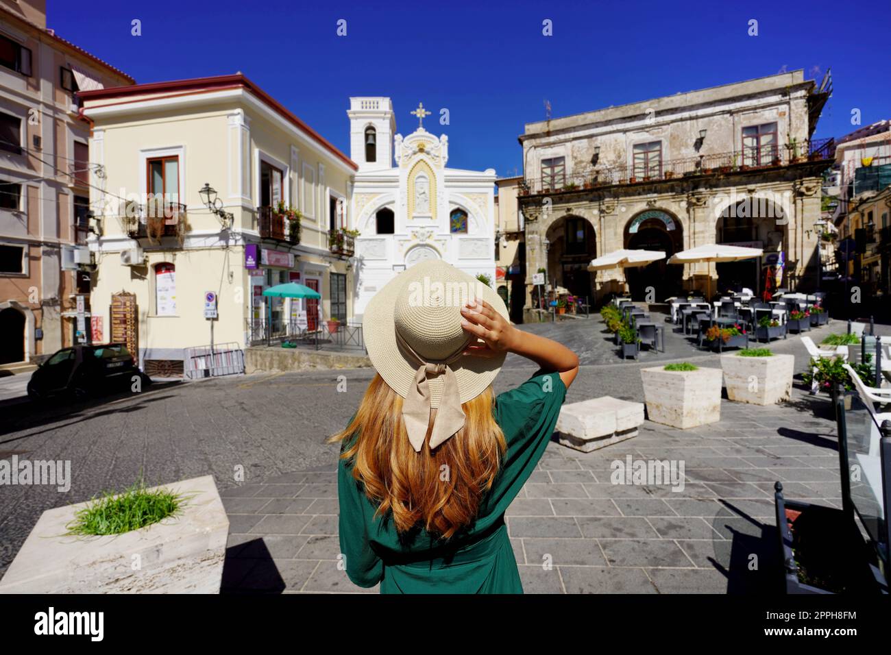 Visite de Calabre en Italie. Vue arrière de la jeune femme avec chapeau de paille marchant dans le centre historique de Pizzo Calabro, Italie. Banque D'Images