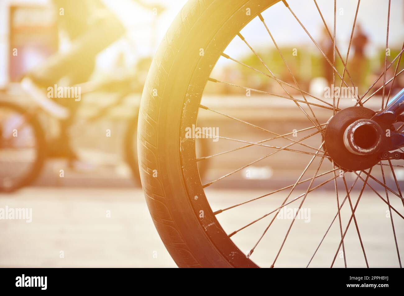 Une roue de vélo BMX dans le contexte d'une rue avec des coureurs cyclistes brouillée. Extreme Sports Concept Banque D'Images
