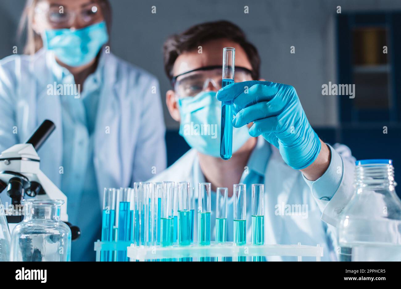 Le médecin du laboratoire analyse des échantillons de codiv-9 au microscope Banque D'Images