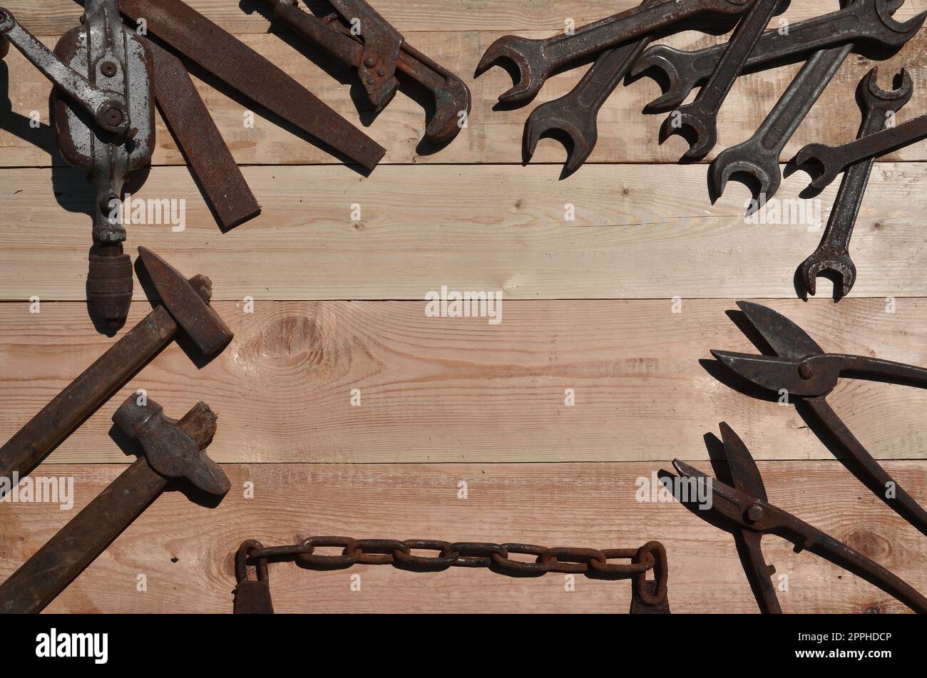 Un ensemble d'outils anciens et rouillés repose sur une table en bois dans l'atelier Banque D'Images