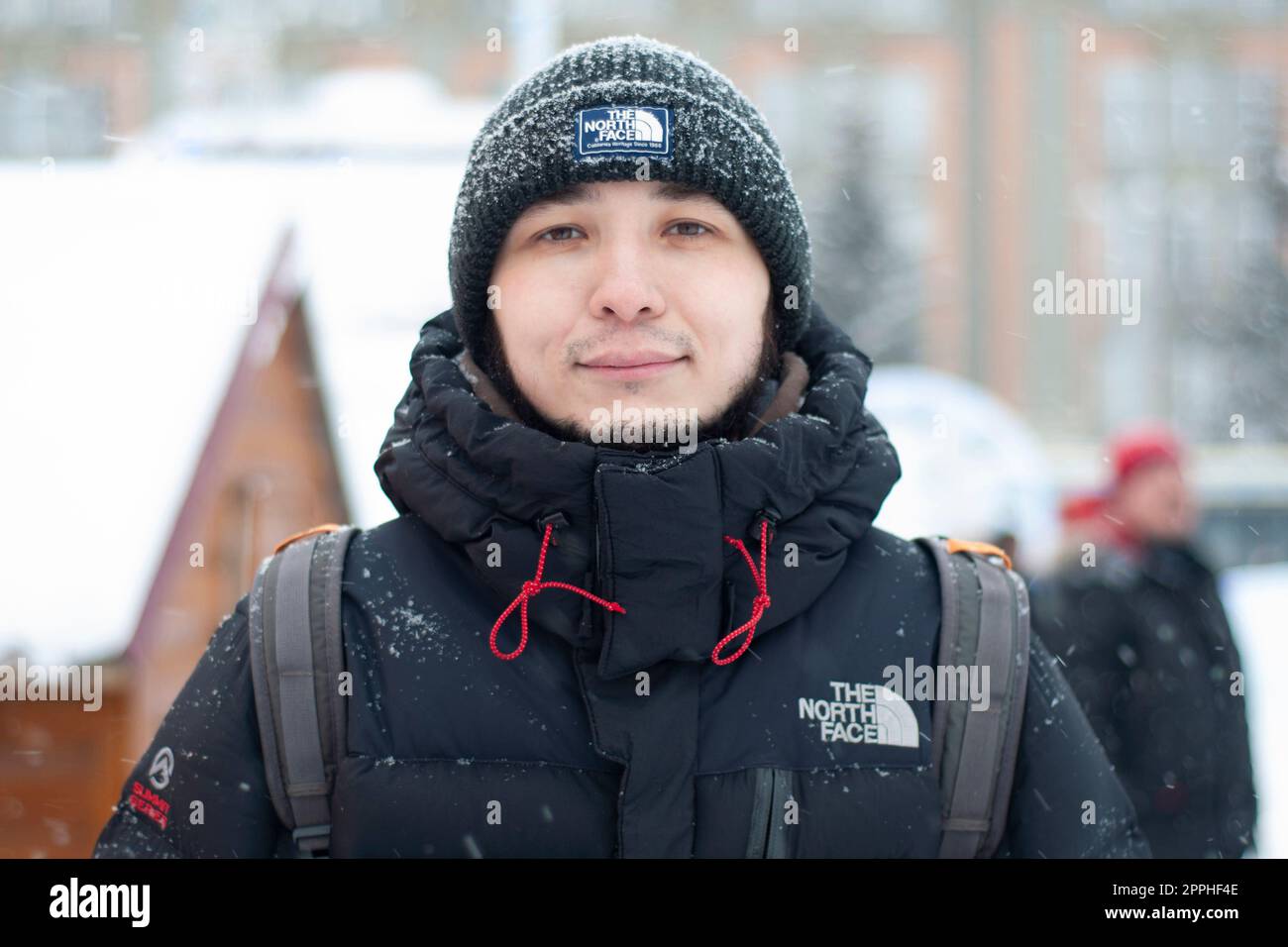 Moscou, Russie - 01 mars 2022 : un homme du dos dans une veste noire et dans une brochette près de la face nord, en hiver. Le logo de l'entreprise de vêtements 'The North face'. Banque D'Images