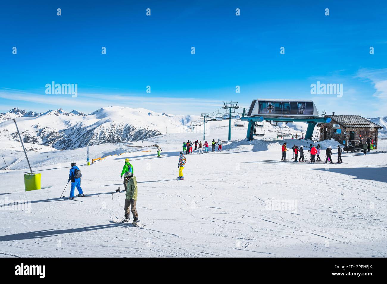 Skieurs et snowboarders sortant des remontées mécaniques au sommet de la montagne en Andorre Banque D'Images