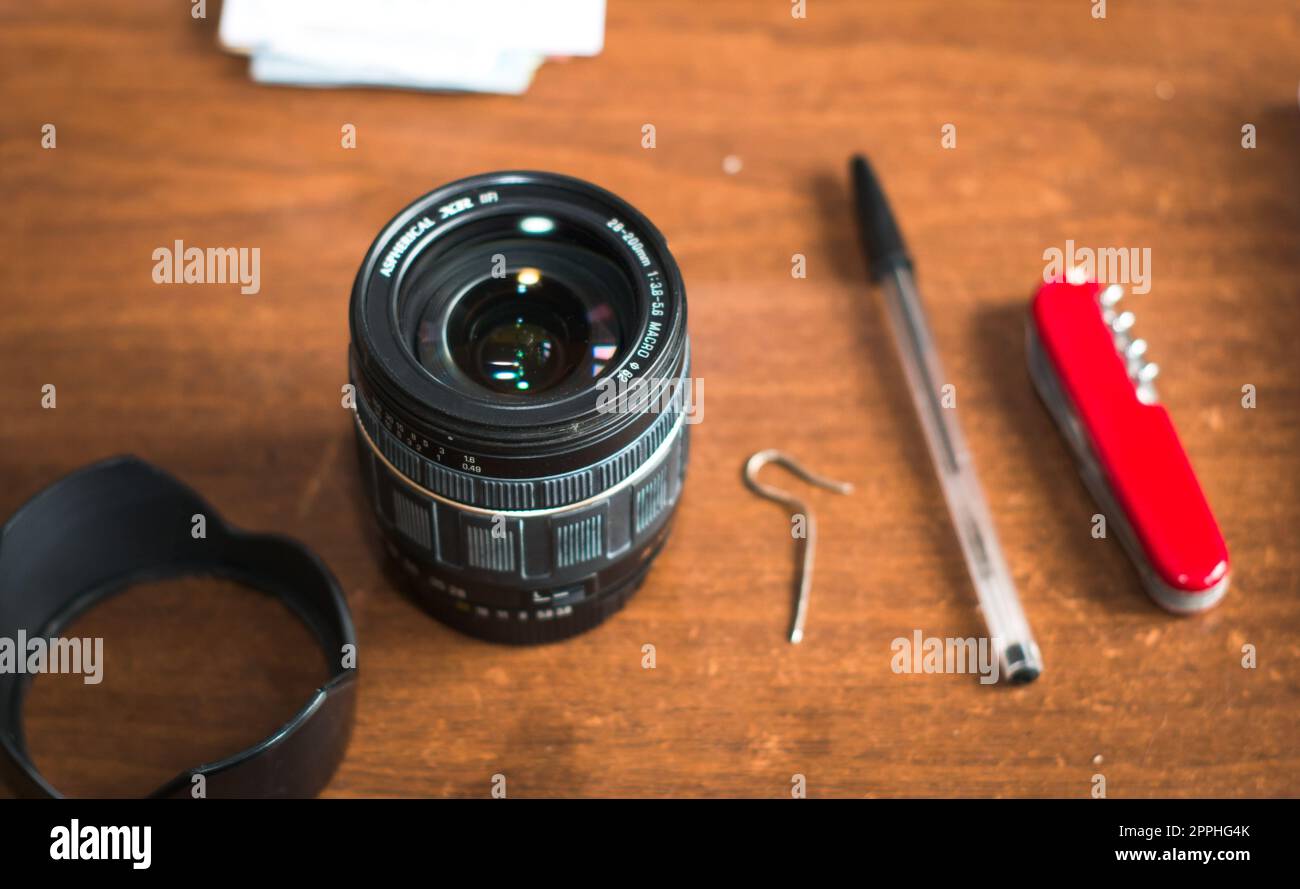 Objectif zoom de l'appareil photo sur une table en bois. Photo authentique d'un espace de travail photographique. Banque D'Images