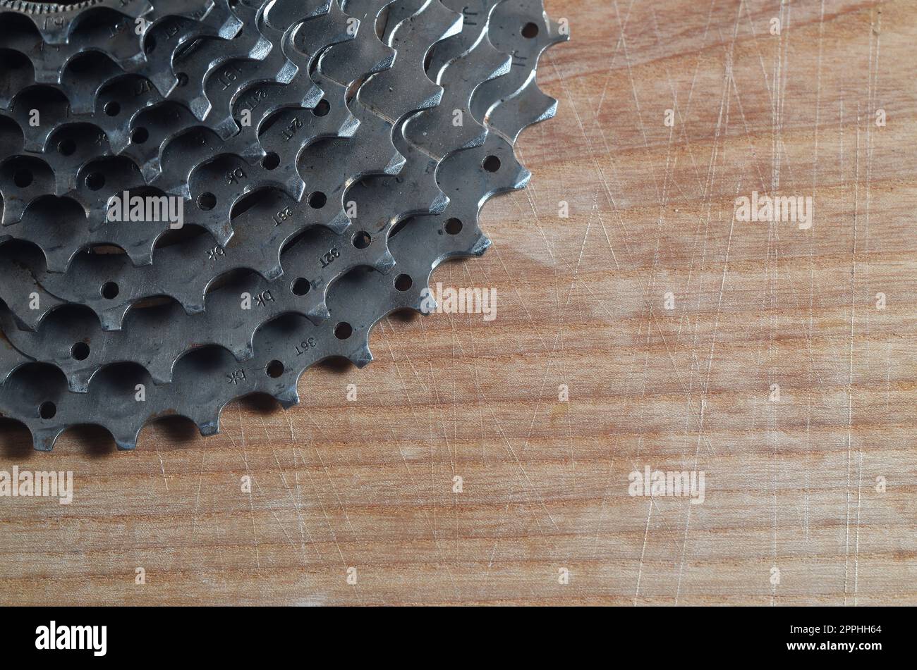 Cassette arrière (pignon) d'un vélo de montagne couché sur une table en bois dans un magasin de vélos Banque D'Images