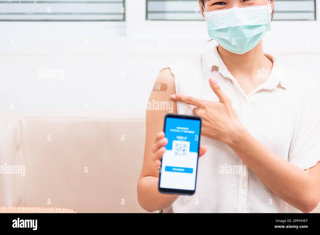 femme montrant du plâtre adhésif sur le bras elle a vacciné et montrant l'application smartphone écran numérique mobile vacciné Banque D'Images