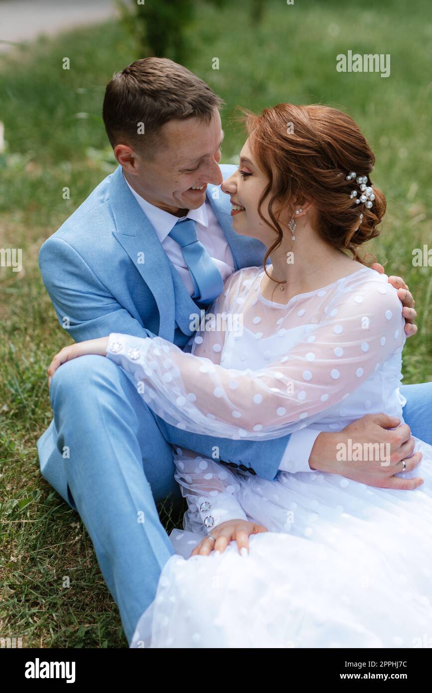 mariée dans une robe de mariée légère au marié dans un costume bleu Banque D'Images