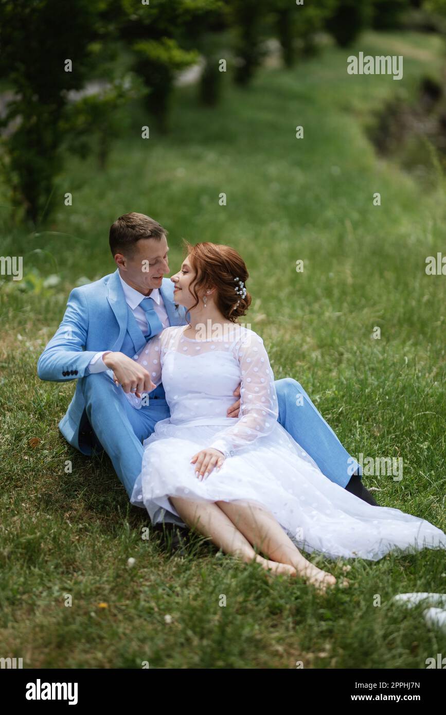 mariée dans une robe de mariée légère au marié dans un costume bleu Banque D'Images