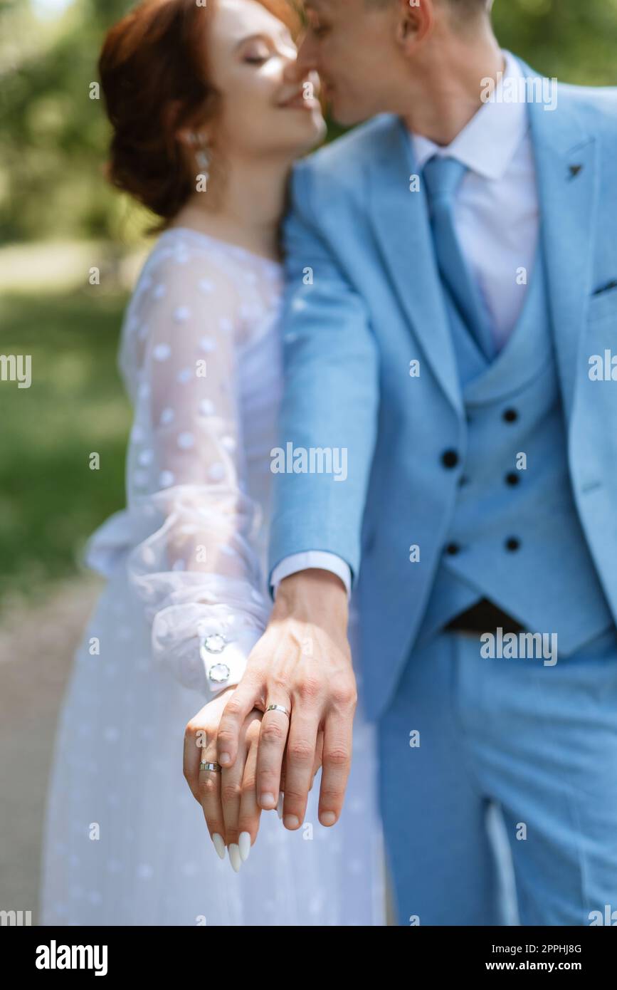 mariée dans une robe de mariée légère au marié dans un costume bleu Banque D'Images