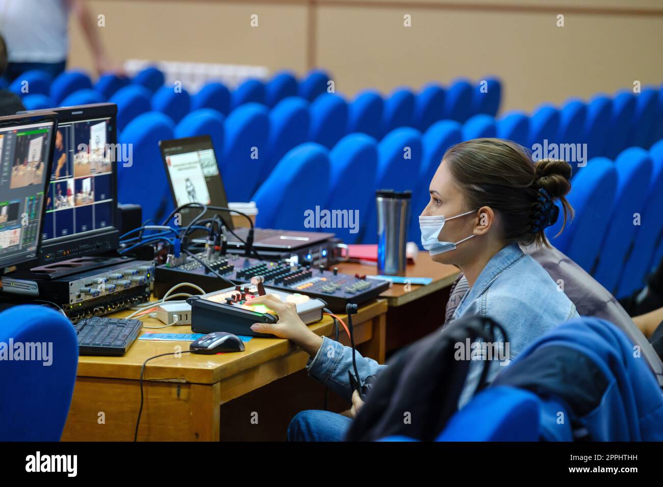 Jeune femme éditeur vidéo dans masque de protection travaillant sur la conférence, séminaire, utiliser l'ordinateur portable de montage vidéo pour la diffusion sur Internet, les médias sociaux Banque D'Images