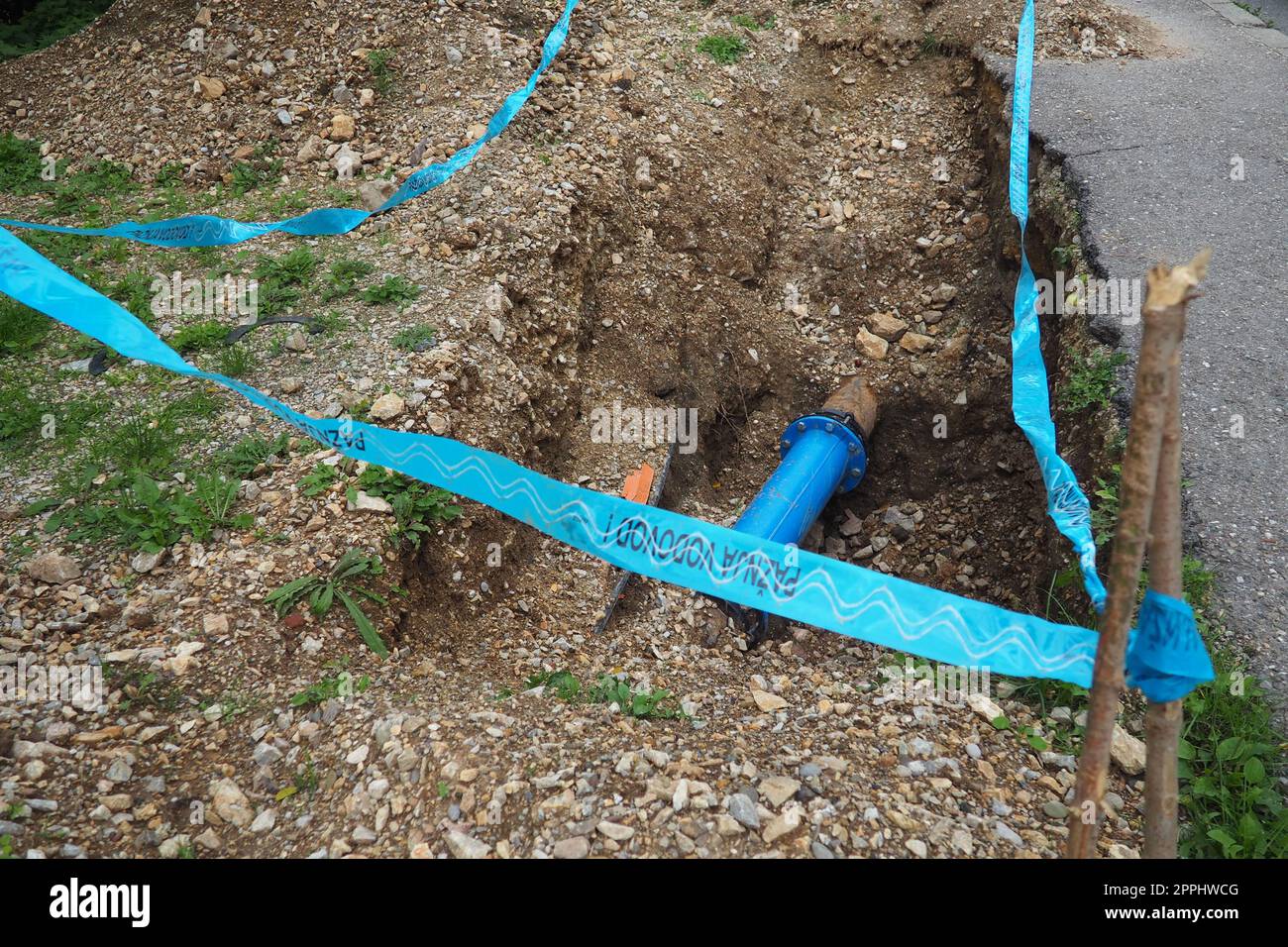 Terrain brisé, trou. Conduites d'eau bleues. Réparation du réseau d'adduction d'eau de la ville. L'inscription en serbe - attention, plomberie. Travaux de terrassement des services municipaux. Dépréciation et amortissement Banque D'Images