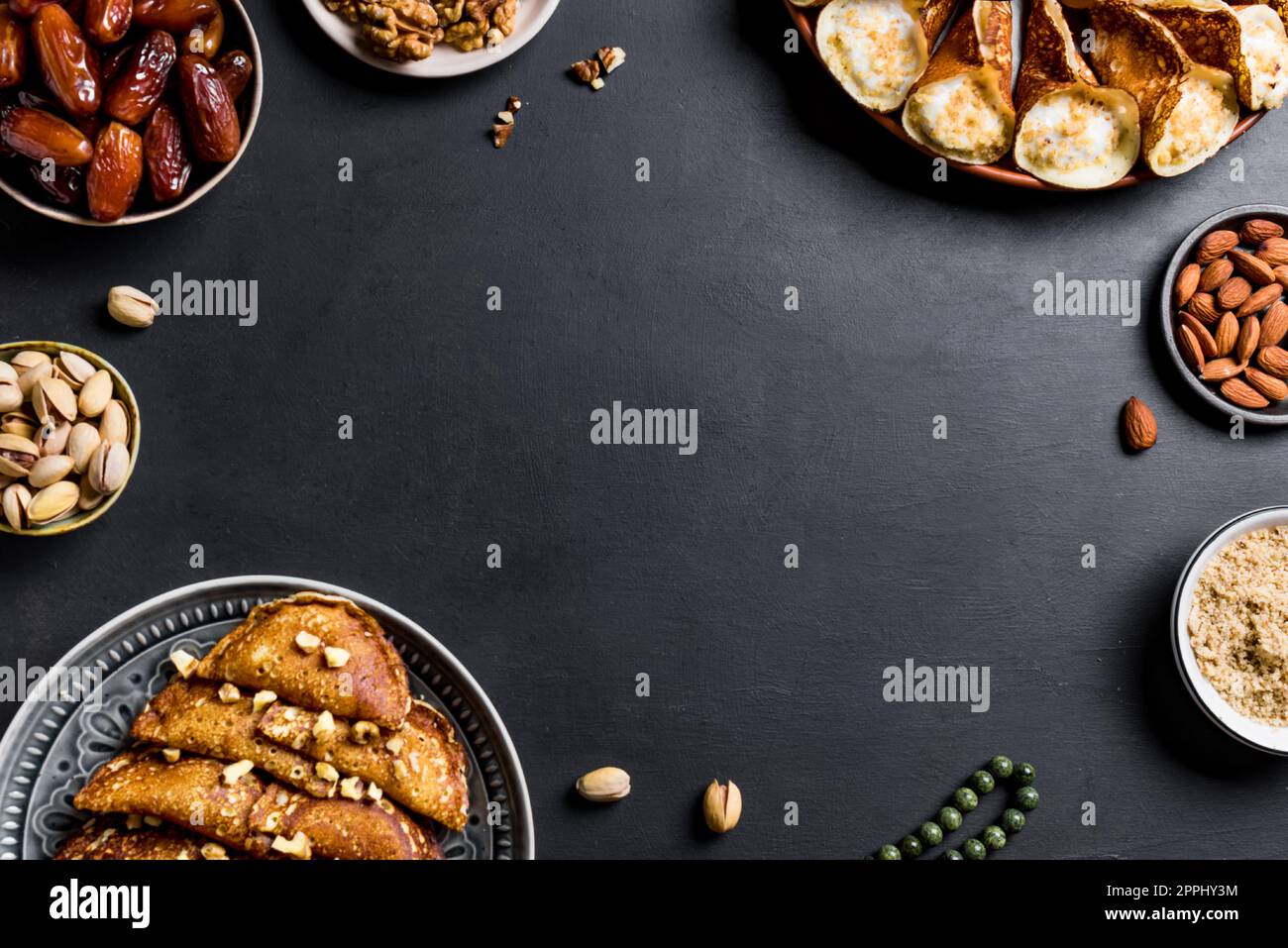 Ramadan iftar food - fruits dattes, dessert qataef maison, divers noix sur le noir, vue du dessus, espace copie. Concept de Kareem de Ramadan. Banque D'Images