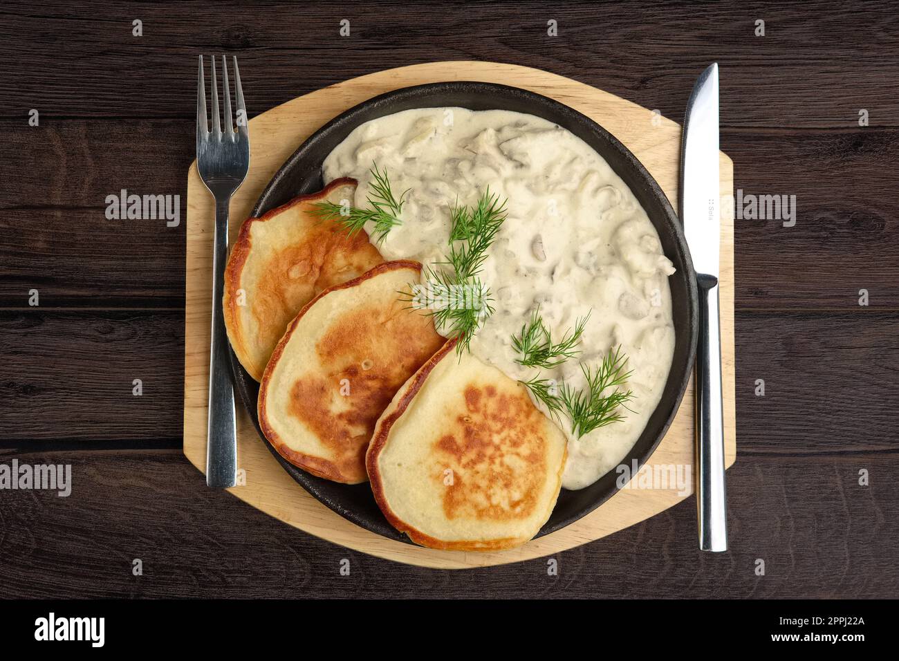 Crêpes aux champignons sur plaque de bois. Vue d'en haut. Banque D'Images