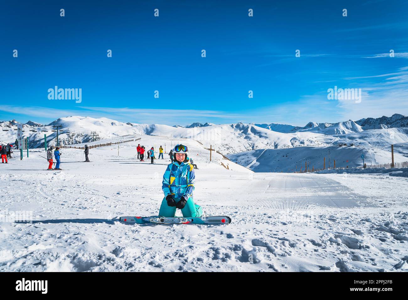 Portrait d'une femme skieuse regardant la caméra avec des gens skiant sur  le dos, montagnes des Pyrénées, Andorre Photo Stock - Alamy