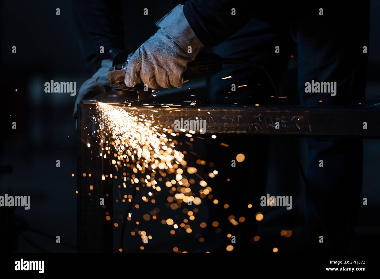 Homme travaillant sur un fer à repasser avec une meuleuse.Homme au travail.Des étincelles et le feu de la coupe du moulin.Meuleuse.Employé. Banque D'Images