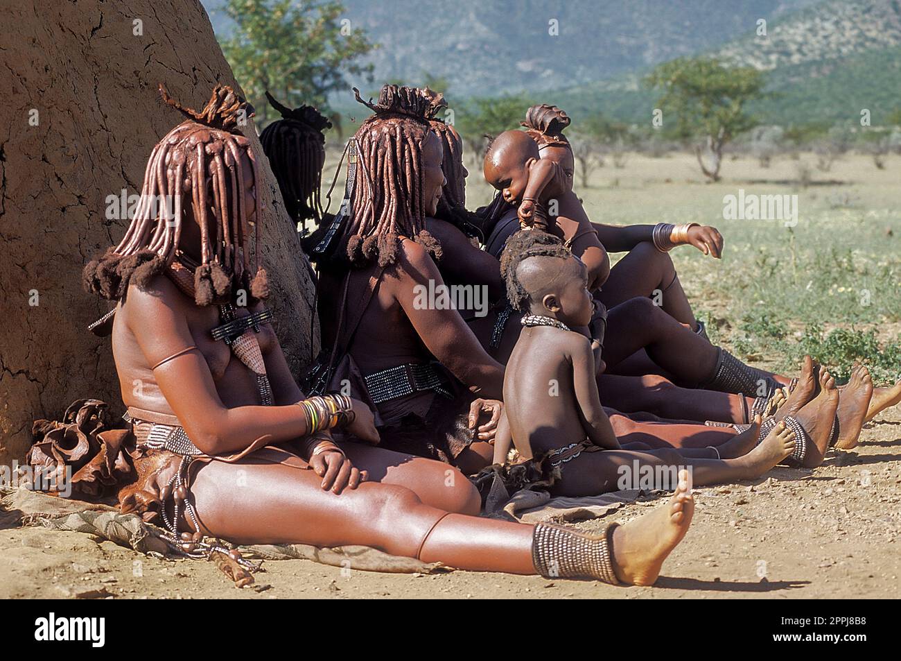 15 mai 2005. Les femmes Himba n'identifient pas leurs enfants avec la coiffure traditionnelle, collier et peau d'ocre typique. Epupa Falls, Kaokoland ou Kunene Banque D'Images