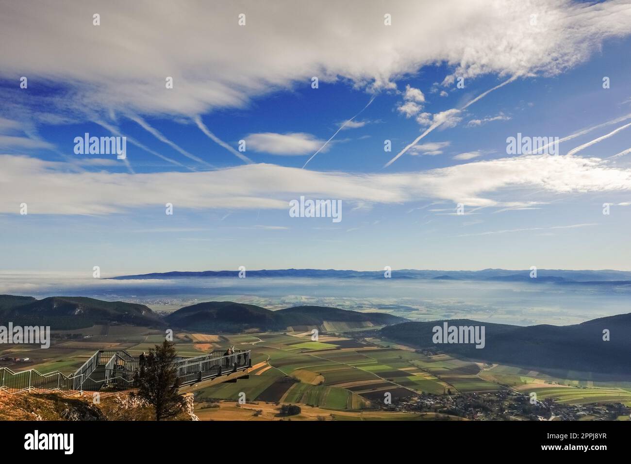 ciel bleu avec des nuages blancs et une large vue sur une vallée verte avec un brouillard dense Banque D'Images