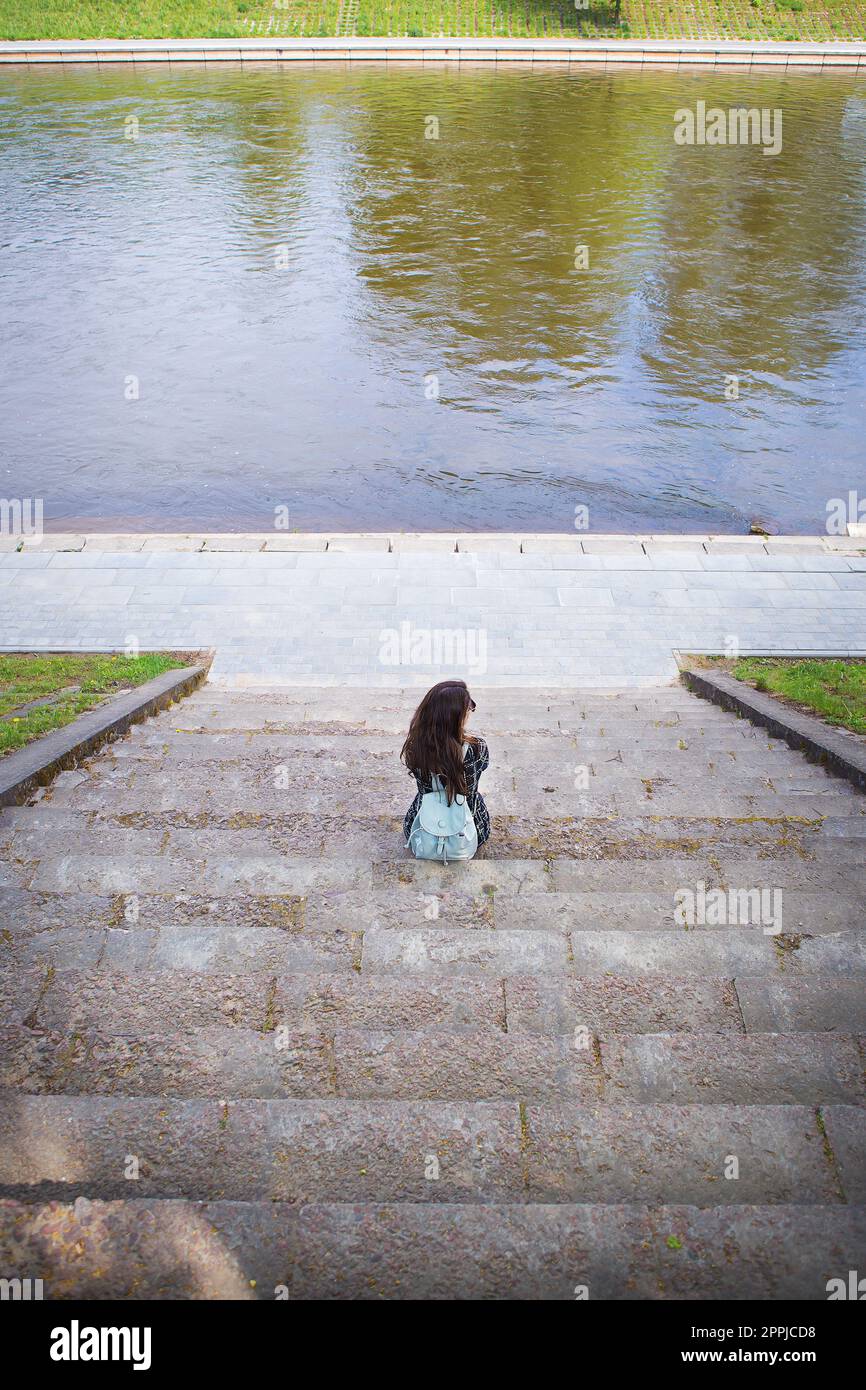 Belle fille est assise et regarde la rivière Vilnius Banque D'Images