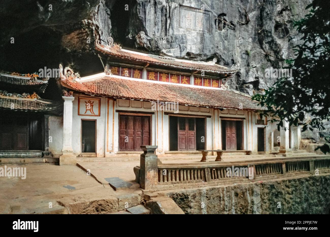 Diapositive numérisée d'une photographie en couleur historique d'un complexe de temples bouddhistes au pied d'un rocher dans le nord du Vietnam Banque D'Images