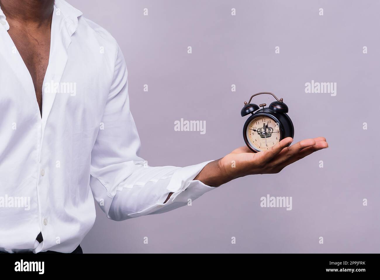 Concept de gestion du temps. Homme noir choqué tenant l'horloge murale, en panne de temps. Banque D'Images