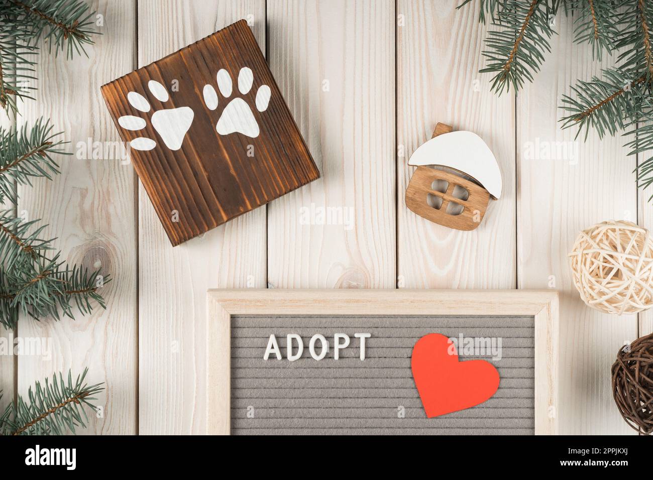 Composition créative d'art de planche en bois avec deux pattes d'animaux, modèle de maison et adopter la planche avec la décoration de brindille de sapin Banque D'Images
