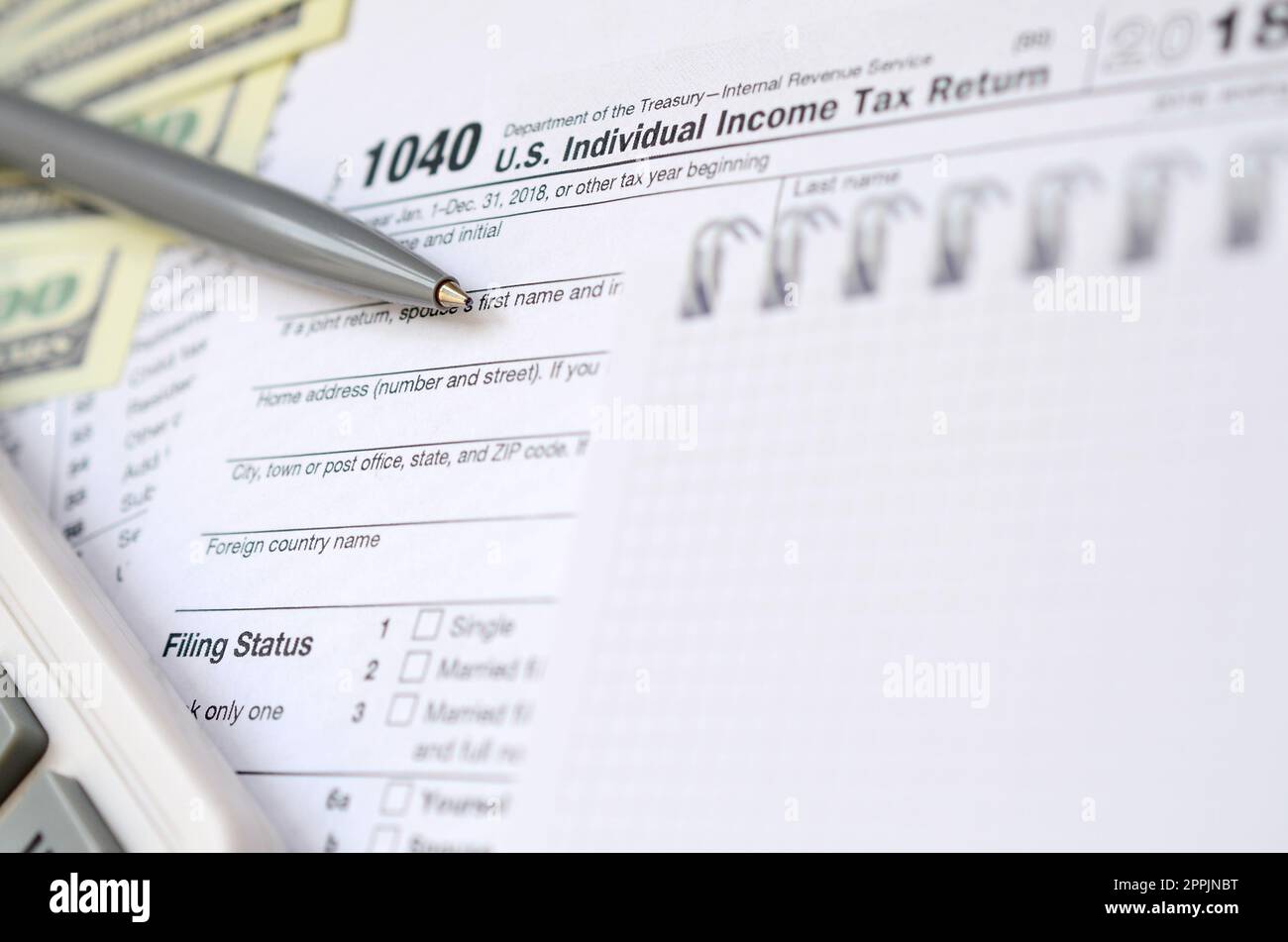 Le stylo, le carnet de notes, la calculatrice et les billets en dollars se trouvent sur le formulaire d'impôt 1040 Déclaration De revenus Des Particuliers des États-Unis. Le temps de payer les taxes Banque D'Images
